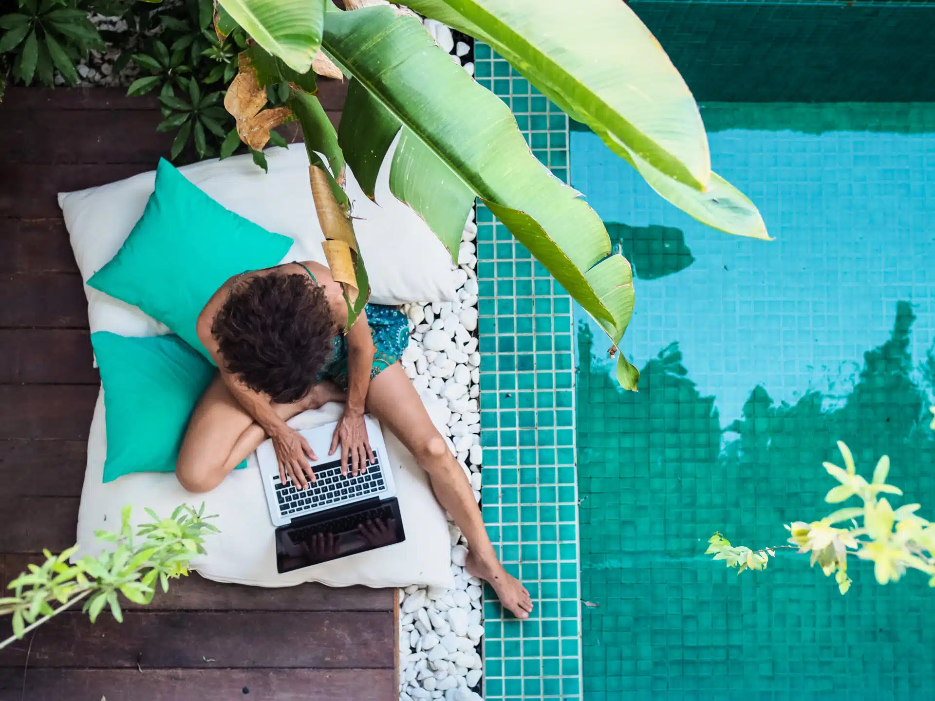 Digital nomad working by a pool