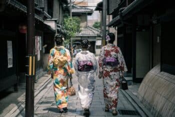 3 ladies in traditional kimonos walking down a village street