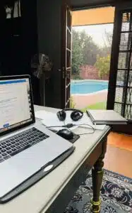 Anina's desk and laptop with a view of her garden and swimming pool
