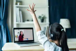 Asian Young Learner raising her hand in an online classroom