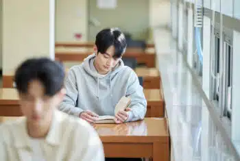 South Korean student reading at a desk in a classroom