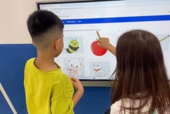 Timea with a boy student at a whiteboard