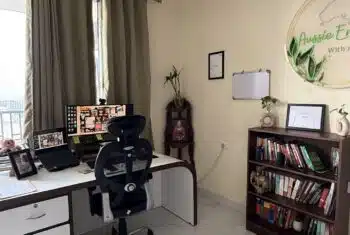 Organised online teaching workspace with laptop, notebook, and headset