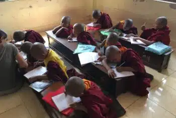 English lesson for monks with notebooks and learning materials