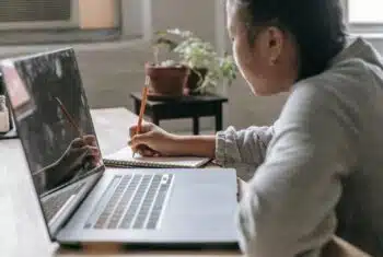Young student actively participating in an online learning activity on a laptop.