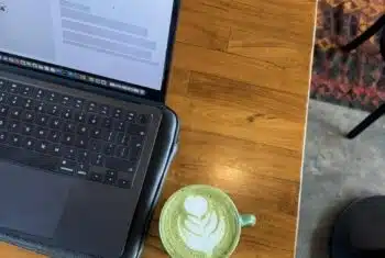 online English teaching setup in a cafe featuring a laptop and a matcha